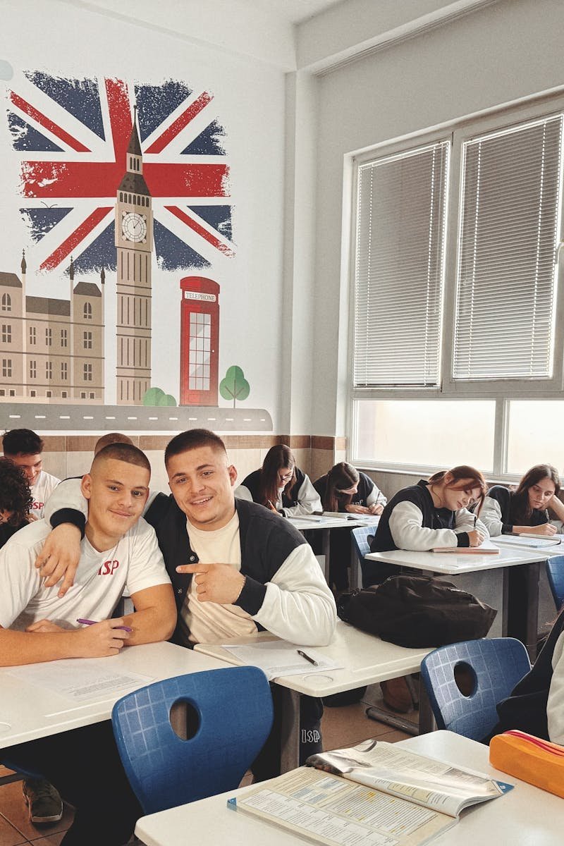 Students studying in a classroom featuring a mural of London landmarks and British flag.